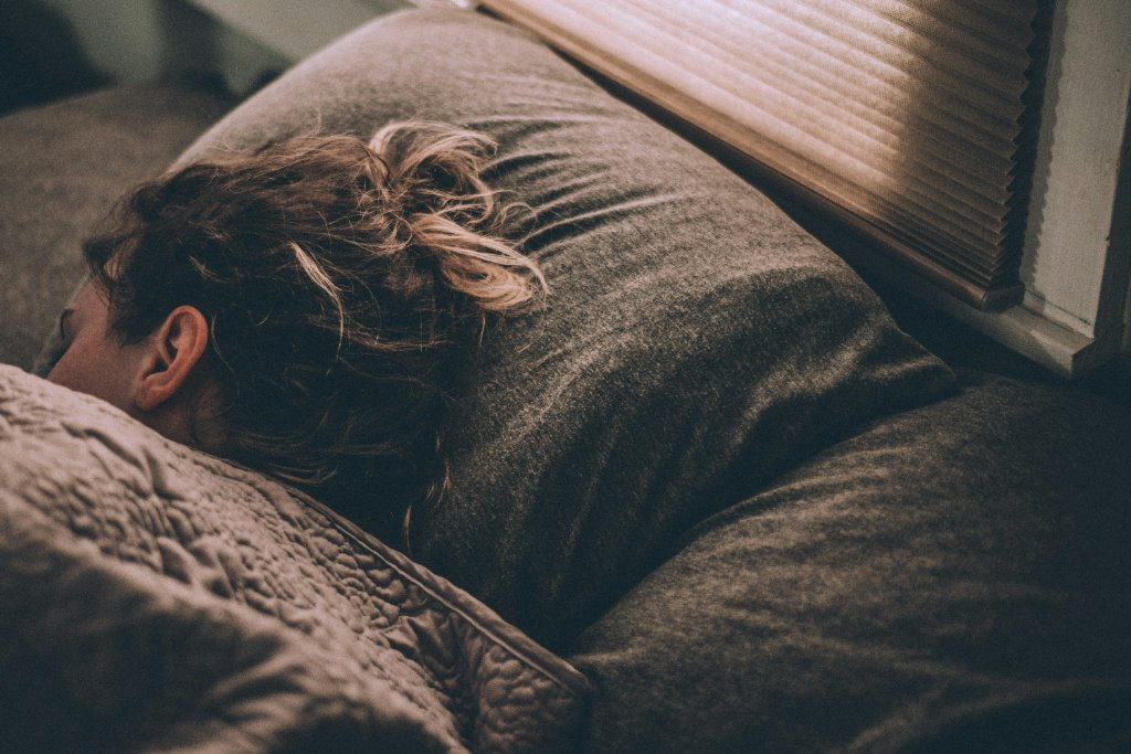 Person sleeping peacefully in bed, wrapped in soft blankets